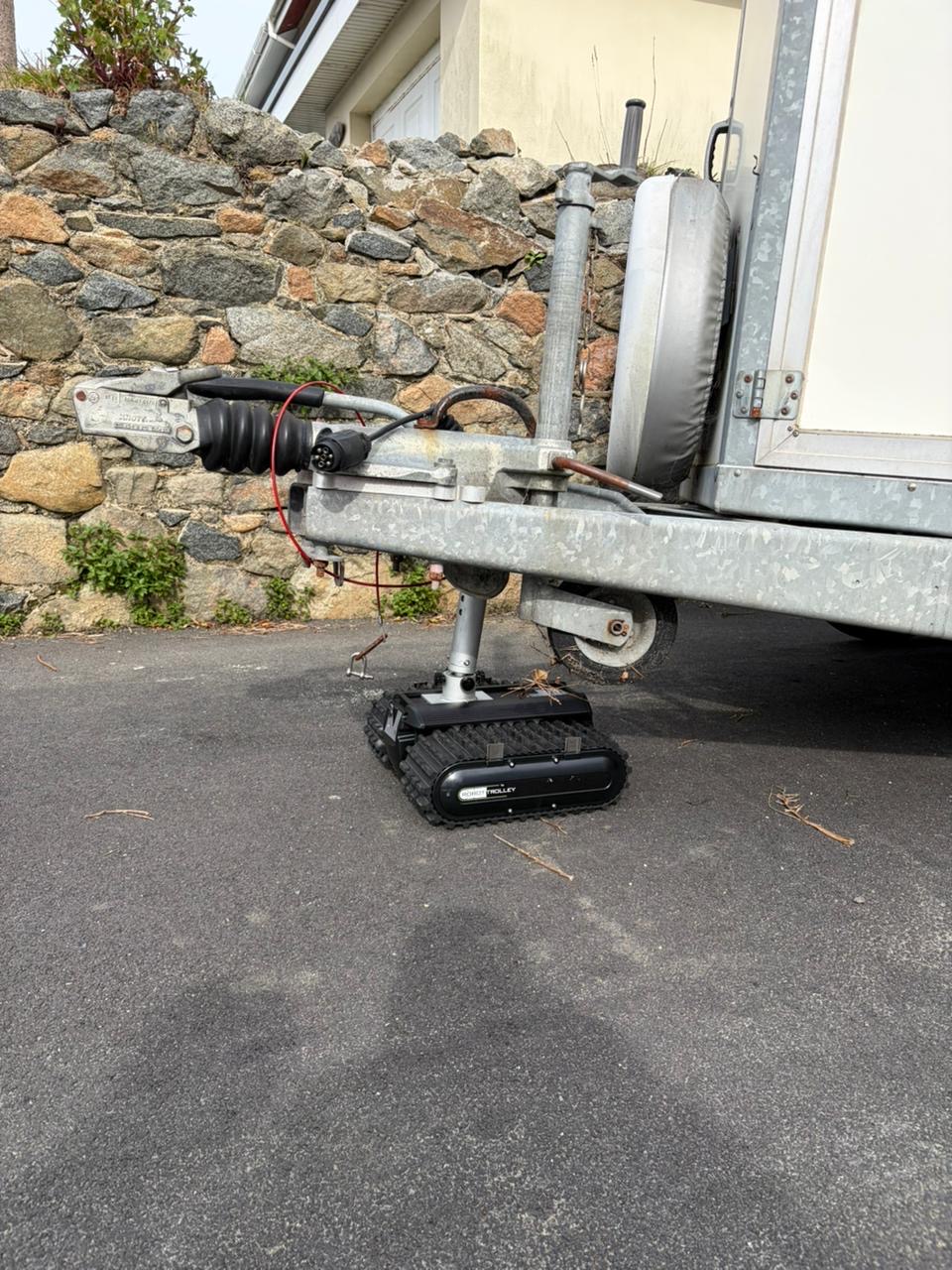 Tracked robot mover positioning a kitchen pod trailer in a tight Guernsey driveway
